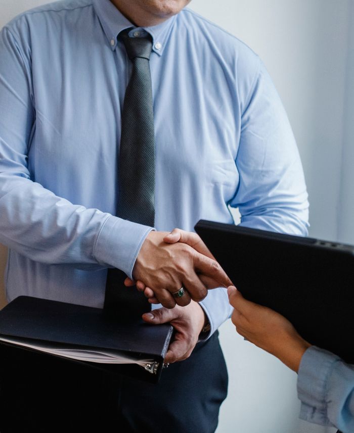 home-services-03 Faceless coworkers in formal clothes shaking hands during meeting at work in light office